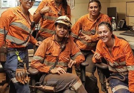 Five women in mining wearing dirty PPE